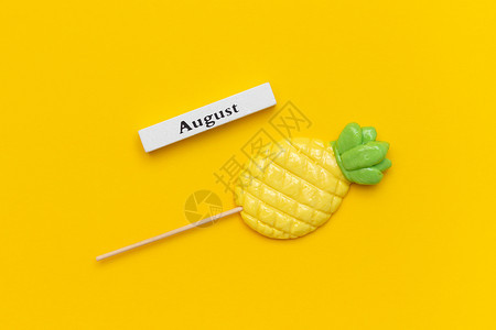 卡片蜜饯木日历夏季月份八和菠萝棒糖在黄色背景上概念假期或你好八月创意顶视图模板木日历夏季月份八和菠萝棒糖在黄色背景上概念假期或你图片