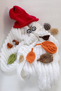 冬叶在寒冷的白天掉头落地Xma节日艺术设计作品与白色围巾红帽子眼睛和编织的毛线叶中懒惰雪人亲手制作的圣诞背景手工制作的懒惰抽象图片