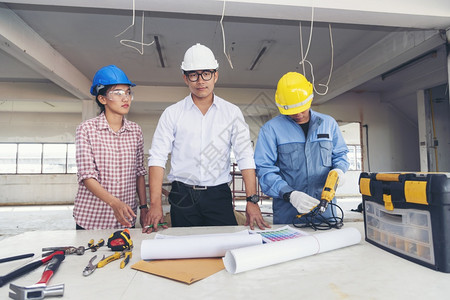 团体在职的建筑工程师团队作安全信托小组负责在建筑工地硬帽子保护主任和土建工程师概念上安装白色黄全硬帽保设备C建筑工程师团队套装图片