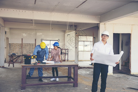 解构建筑工程师团队作安全信托小组负责在建筑工地硬帽子保护主任和土建工程师概念上安装白色黄全硬帽保设备C建筑工程师团队人们年轻的图片