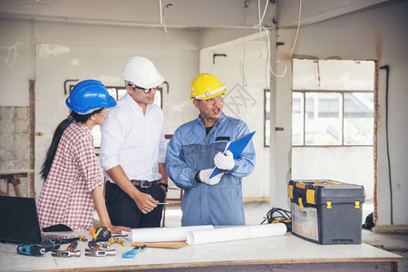 工厂建筑学年轻的工程师团队作安全信托小组负责在建筑工地硬帽子保护主任和土建工程师概念上安装白色黄全硬帽保设备C建筑工程师团队交易背景