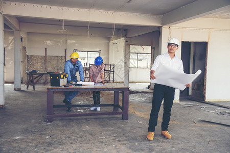 建筑工程师团队作安全信托小组负责在建筑工地硬帽子保护主任和土建工程师概念上安装白色黄全硬帽保设备C建筑工程师团队商人保持工图片