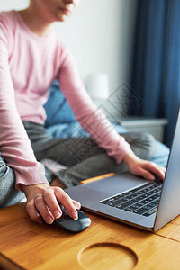 工作室内的正面在COVID19隔离在线课程教中在家电脑上远程用笔记本电脑完成学校任务的少女学习在计算机面前坐床边看屏幕的女远程孩图片