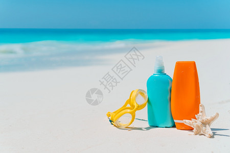 风镜白沙滩背景的上太阳淇淋瓶护目镜海星和太阳墨镜海洋中的太阳奶瓶眼镜白沙滩上的海星晴天皮肤图片