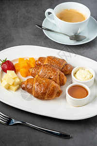 法国羊角面包新鲜烤牛角面包含蜜和黄油的黑石本底起司咖啡店金的图片