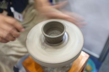 手陶瓷制品技术将粘土碗扔在陶瓷树皮轮上的人陶瓷工讲习班背景图片