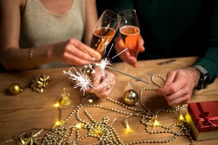 吸引人的幸福情侣拿着火花和香槟杯新年派对笑有趣的图片
