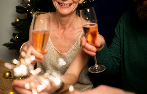 年轻的有趣喜庆幸福情侣拿着火花和香槟杯新年派对图片
