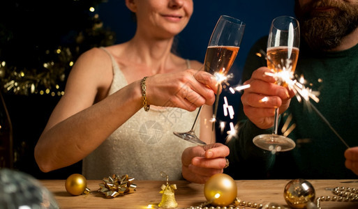 白色的幸福情侣拿着火花和香槟杯新年派对香槟酒假期图片