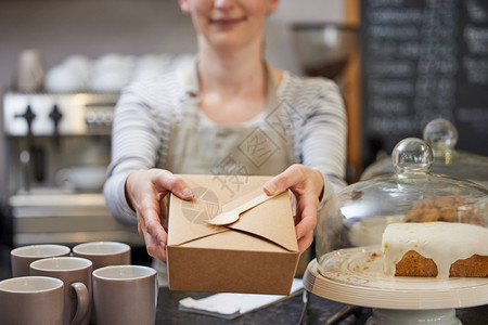 纸板50年代在用木质叉子可持续回收包装中为餐饮提供食物的咖啡厅近距离女工人零售图片