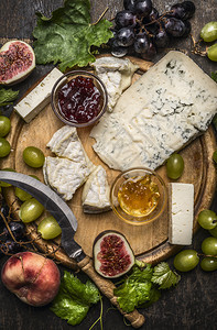 吃白奶酪和黑葡萄蜂蜜木板上的果酱在黑暗生锈背景最接近的顶端视线上贴木制切割板产品法语图片
