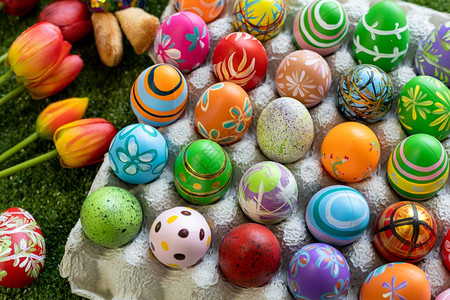 颜色早餐玩具娃复活节概念彩色复活节鸡蛋在有空间的绿草背景中以蛋箱篮子复活节鸡蛋糖果篮子兔娃图片