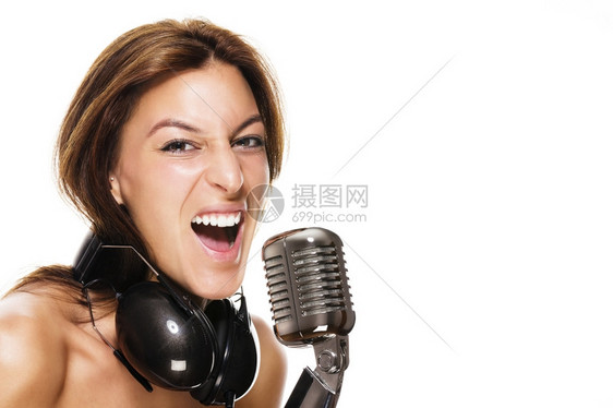 嗓音年轻女歌手带耳机和白背景麦克风的年轻女歌手漂亮的音乐会图片