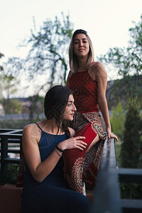 户外屋闺蜜两个年轻的天主教女青年在阳台上观看日落的光芒图片