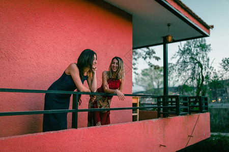 两个年轻的天主教女青年在阳台上观看日落的光芒漂亮金发女郎放松图片