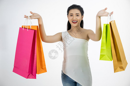 美丽的亚洲女孩拿着购物袋笑愉快吸引人的时尚图片
