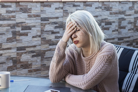 美丽的悲哀不快乐女人坐在家里的阳台上郁闷孤独图片