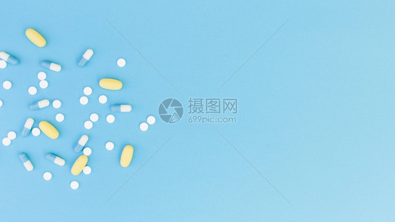 蓝色背景上的药片和胶囊图片