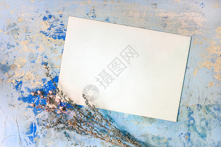 浅褐色的晒干礼物旧贺卡牌有复制文字或照片的印本地方白信封和用蓝木纸板和木彩花在背景上的老旧陈腐薄膜上干鲜花图片