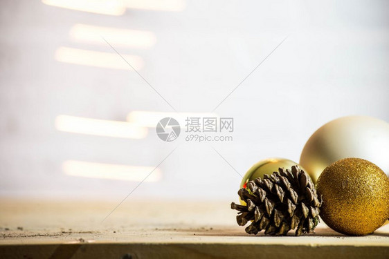 季节冷杉象征装饰有金棕榈球的松果瓜装饰圣诞节背景布局色彩多的火花设计装饰松果子配金色圣诞球装饰背景布局图片