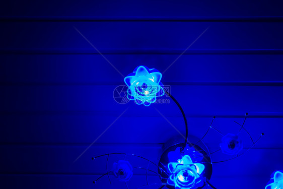 现代的室内电灯泡背景一盏光亮的现代灯装饰在天花板上挂着鲜在黑暗中照亮蓝光图片