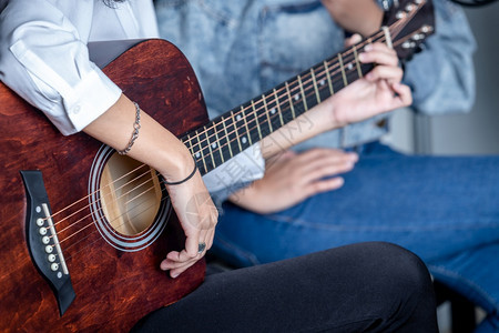 两只紧的女手指握着调解人用吉他在录音室制一首歌乐趣男玩图片