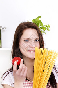面条一位年轻女肖像配着意大利面和番茄配着意面和番茄的快乐年轻女黄色图片