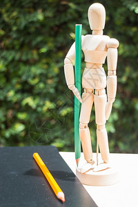 木制艺术家假人配有彩色铅笔和股票照片目的绿色木偶图片