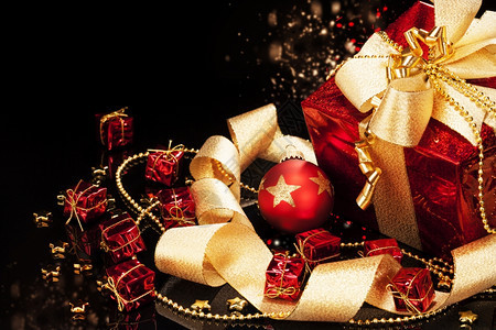 带圣诞球的礼物带红色圣诞球和黑背景丝带的红圣诞礼物金的展示新图片