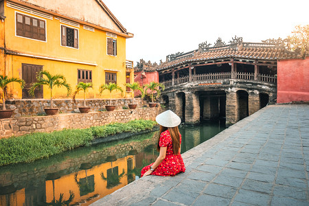 美丽的明亮帽子在越南海安的日本遮盖桥旅行女乘日本大桥图片