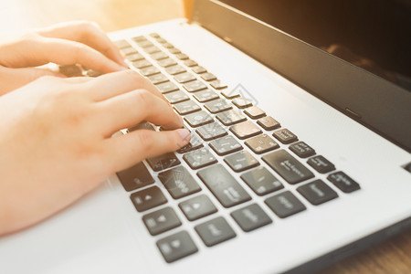 键盘打字女孩聪明的商业在咖啡店像背景一样用笔记本电脑咖啡工作的近身女商人现代的背景