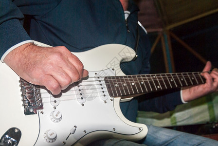电的手臂爵士乐一个男人弹着把白色的电吉他图片