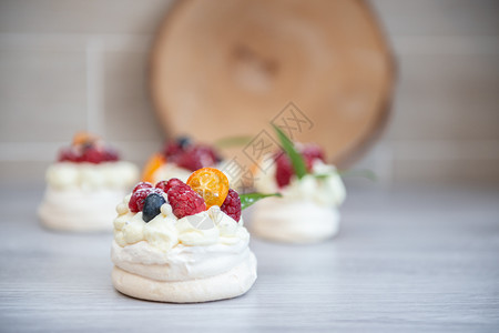 覆盆子配奶油和小水果的Pavlova梅林瓜沙漠蛋糕奶油和小水果烘烤的棕色图片
