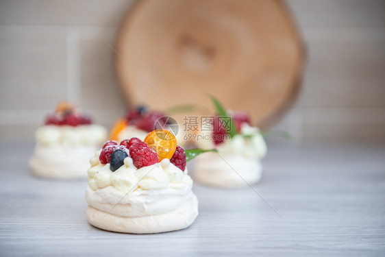 覆盆子配奶油和小水果的Pavlova梅林瓜沙漠蛋糕奶油和小水果烘烤的棕色图片