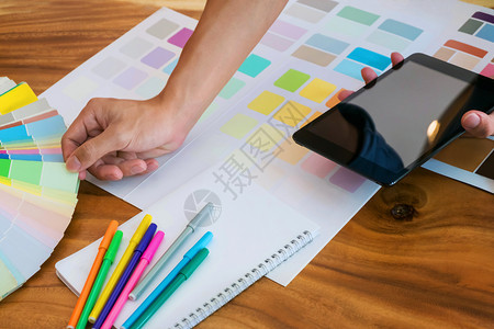 形象的视觉利用平板牌和在现代办公室桌上制作彩色图表的创意商业妇女年轻的图片