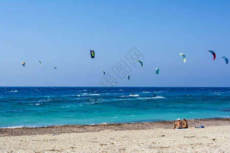 希腊莱夫卡斯岛的AgiosIoannis海滩希腊莱夫卡达岛2016年8月31日希腊莱夫卡斯岛的五颜六色电力风筝从冲浪者横跨天空地图片