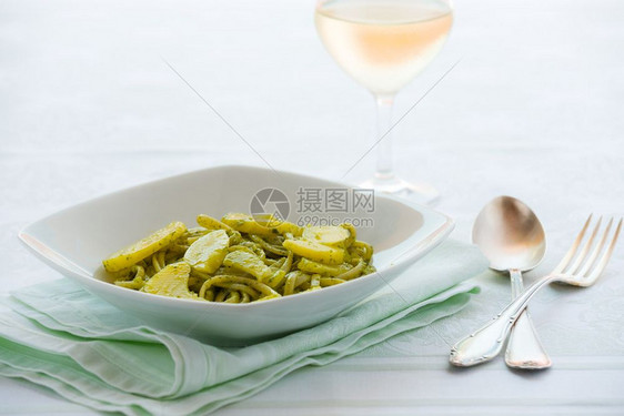 皮诺利餐具和白葡萄酒杯加蔬菜和马铃薯的餐桌上配有蛋白瓜和土豆的意大利面粉及青菜和土豆绿色利古里亚图片