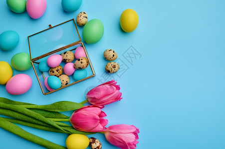 食物彩箱中多的东蛋和蓝底郁金香顶端观食活动装饰春季节日庆祝活动传统标志盒中的复活节鸡蛋和蓝底的郁金香假期生活图片
