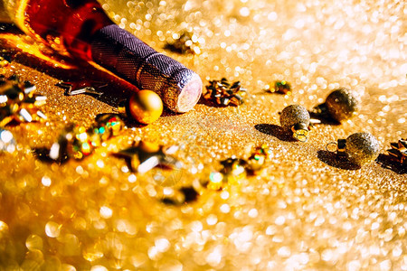 魅力微光乐趣圣诞或新年配有一瓶玫瑰香槟和金色闪亮背景的花彩装饰喜庆布基和影子的侧观以及庆祝党的创造概念以庆祝圣诞节或新年背景图片