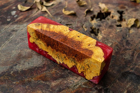 有条纹的塑料在旧桌艺背景上播种红环氧树脂圆木立方体自然Afzelia木粗糙的图片
