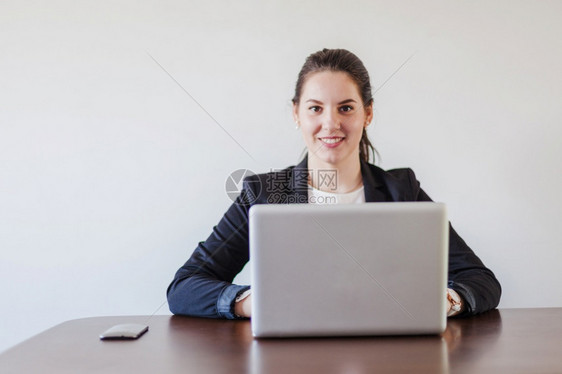 技术有创造力的妇女坐在办公桌工作笔记本电脑女图片
