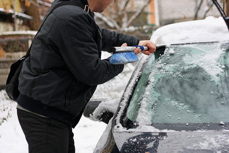 在特殊的刷子帮助下清洁雪车男工在特别的刷子帮助下白色的清算移动图片