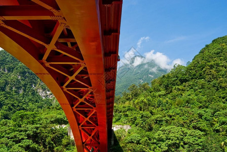 工程横跨山脉的红钢拱桥满山都是绿林户外暂停图片