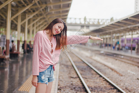 假期浪漫的金属女人将手臂伸向铁路轨道上图片