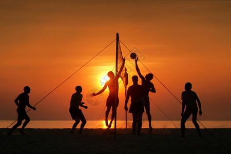 排球剪影青少年海边玩沙滩排球日落剪影背景