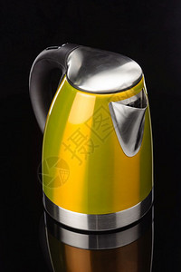黑镜背景上的黄色彩绘不锈钢电水壶黑镜背景上的黄色不锈钢电水壶黑色的黄图片