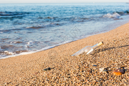笔记玻璃水瓶里有信息在海滩岸边的里面图片