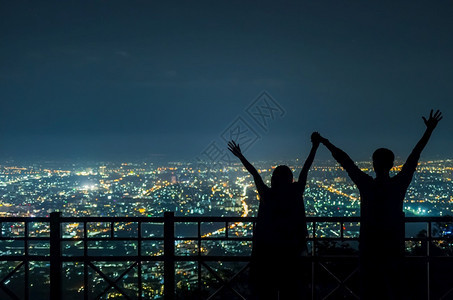 天空喜悦在清迈市之夜双手握表达欢乐的情侣轮光片将一对相爱的情侣Silhouette场景图片