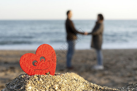 红心在海边的沙山上与一对情侣起在圣valentine的背景概念中家庭自然海洋图片