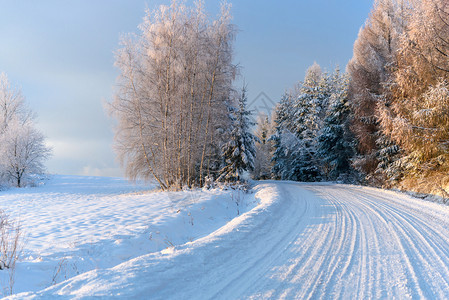 晴天景观速度冬季风寒冷阳光明媚的清晨雪覆盖了山路图片